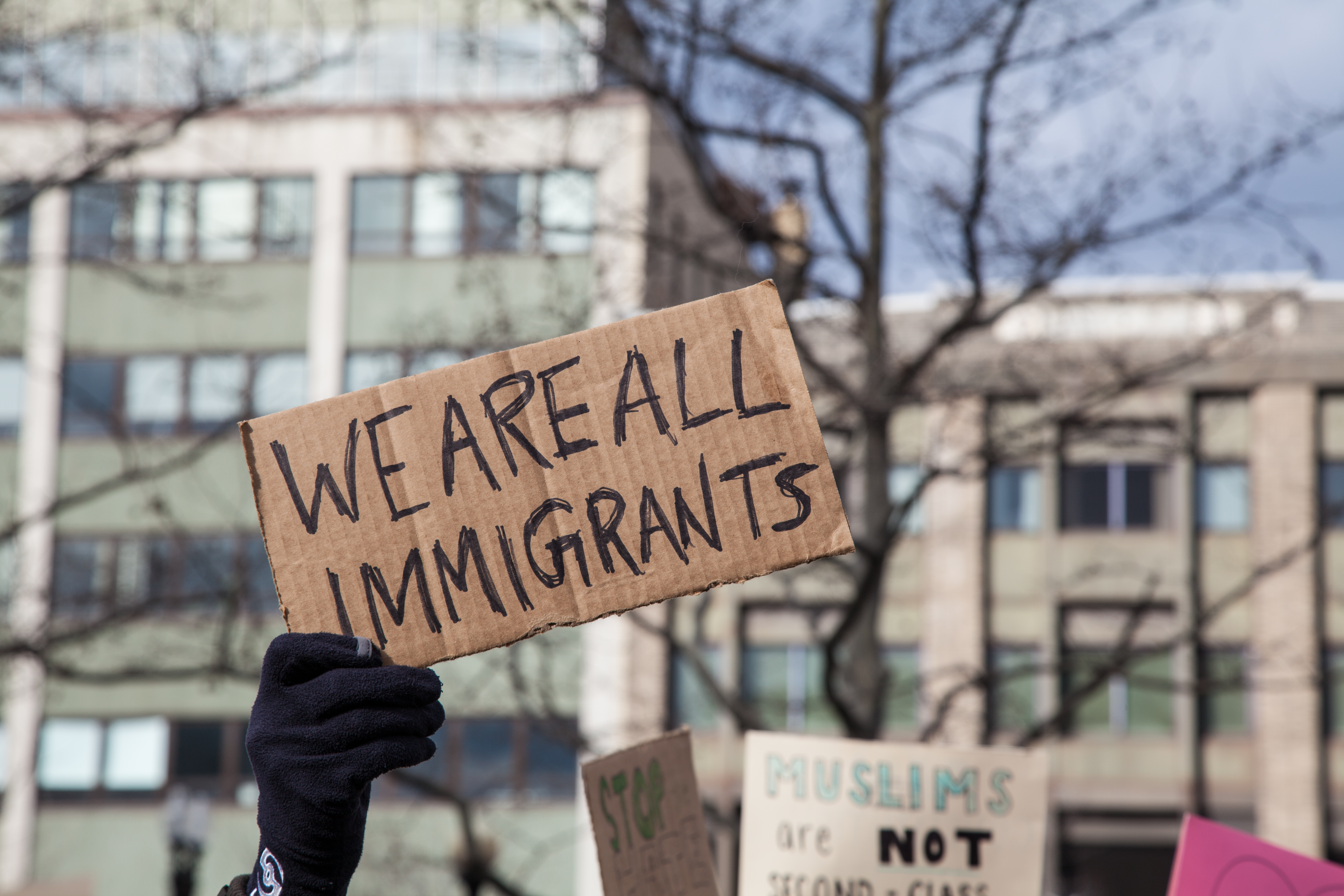 Cardboard sign reading We are all immigrants