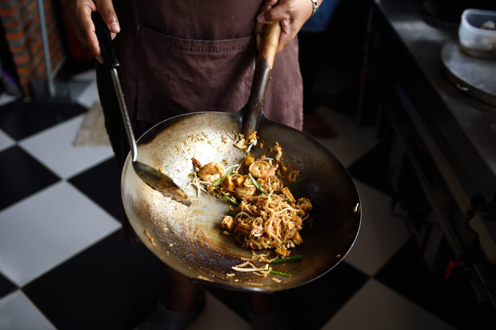cook preparing food in wok